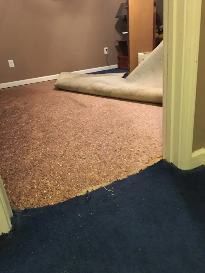 Carpet pad removal revealing water damage during Water Mitigation Services in Atoka